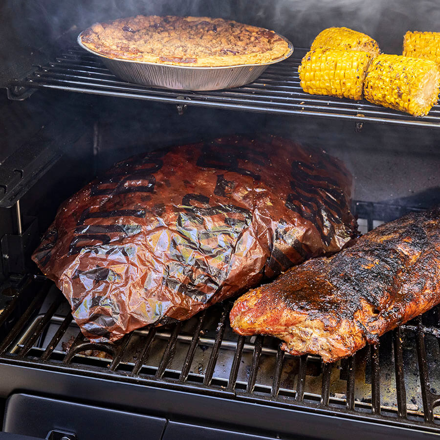 Grilled meat wrapped in butcher paper on a grill