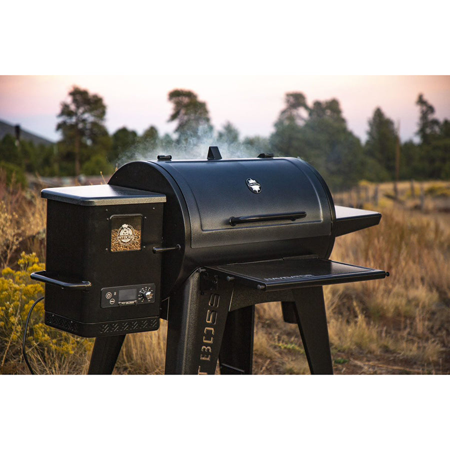 lifestyle photo of smoking grill in grassy field